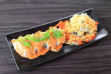 Maki sushi roll wakame deniz yosunu ile Somon üst ve gevrek tempura un, mayonez ve uçan balık Karaca - ile özel sushi üst yapılmış Japon füzyon gıda.