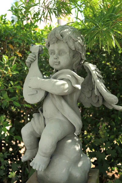 Scultura di angelo bambino decorato in giardino . — Foto Stock