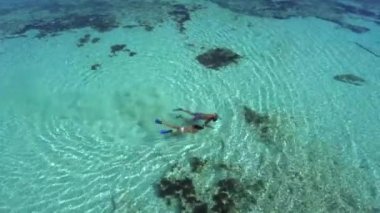 Sığ turkuaz suda şnorkelle yüzen çift