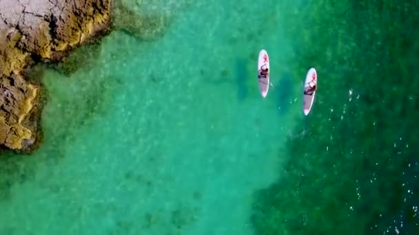 Pareja Stand Paddle Surf Cerca Rocas Agua Tropical Por Dron — Vídeos de Stock