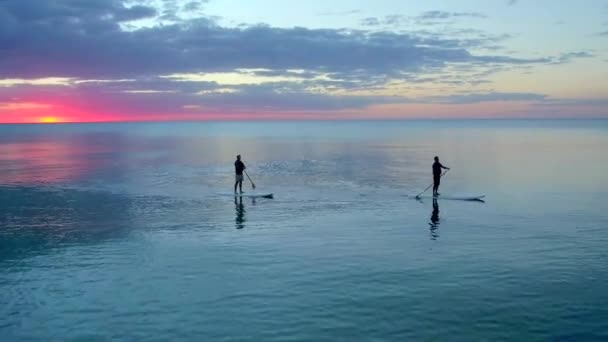 Twee Peddelboarders Bij Zonsondergang Door Luchtdrone — Stockvideo