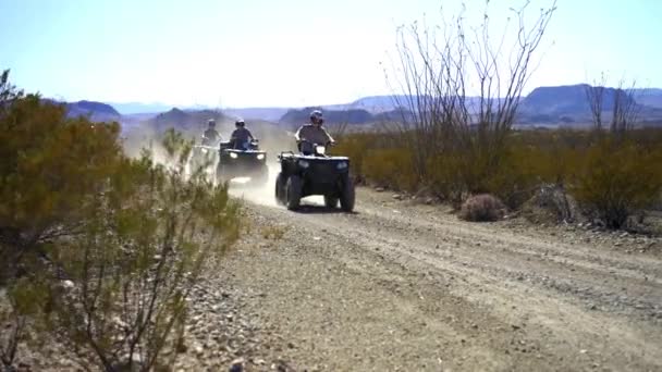 Quads Drive Desert Road Slowly — стоковое видео