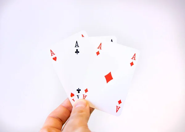 Mano in possesso di un trio di carte Asso di poker su uno sfondo bianco — Foto Stock