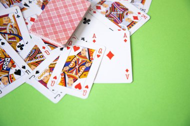 Yeşil arkaplan üzerinde rastgele poker kartları.