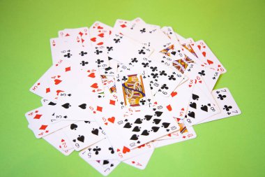 Yeşil arkaplan üzerinde rastgele poker kartları.