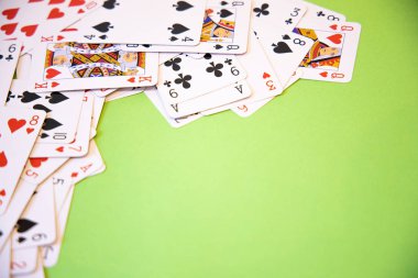 Yeşil arkaplan üzerinde rastgele poker kartları.