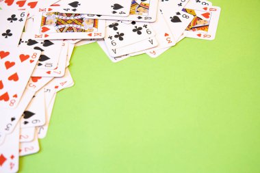 Yeşil arkaplan üzerinde rastgele poker kartları.