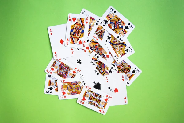 Random Poker cards over a green background.