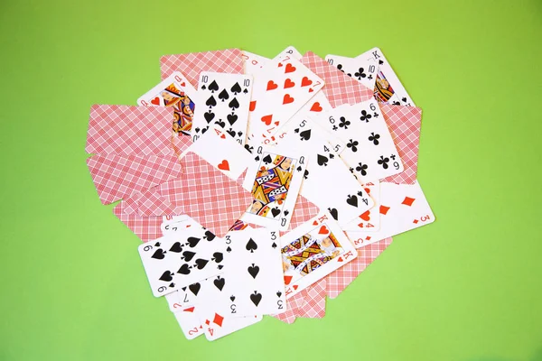 Random Poker cards over a green background.