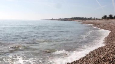 Temiz şeffaf suyu ve rahatlatıcı dalgaları olan bir kumsal manzarası