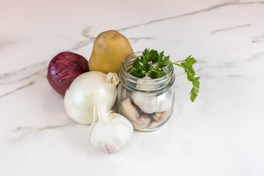 İçinde havuç, patates, soğan, sarımsak ve maydanoz olan çiğ organik sebzeler var..