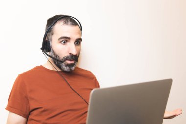 İzole edilmiş, sakallı, evde yardımcı olarak çalışan, şaşırmış bakışlı genç bir adamın görüntüsü..