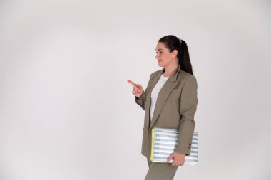 Fotokopi alanı olan gri arka planda başarılı bir iş kadını. Takım elbiseli patron parmak, el ve diğer tarafa bakıyor.