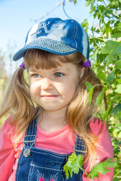 Liten Söt Tjej Mössa Och Overall Grön Trädgård Porträtt — Stockfoto