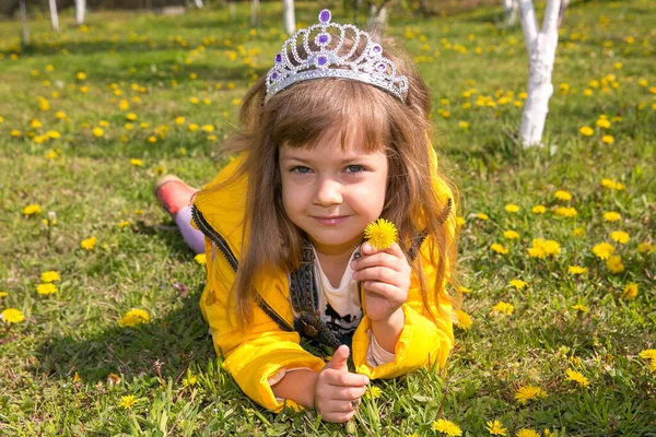 Liten Flicka Gula Kläder Ligger Grönt Gräs Och Massor Maskrosor — Stockfoto