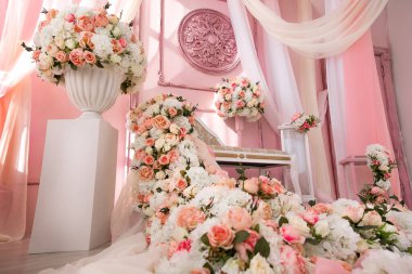 Kanepe ve çiçek bolluğu pembe ve bembeyaz. Güllerden ve öncülerden düşer