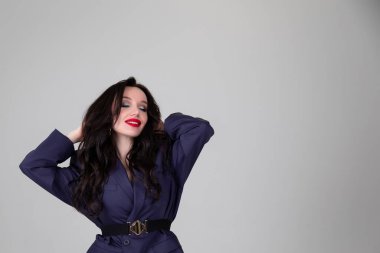 Erkek gibi giyinmiş olarak. Gri arka planda güzel erkek ceketi. Portre