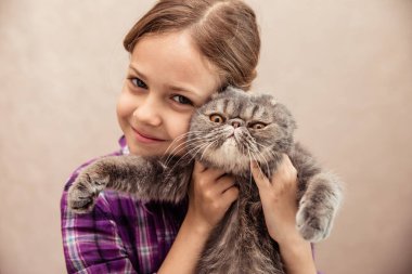 Neşeli kedi yavrusuyla resim yapan kız.