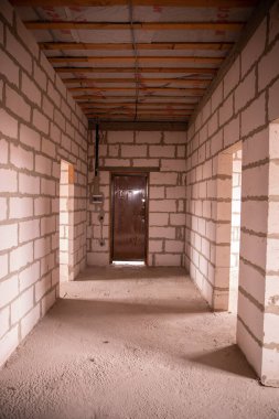 İnşaatçının onarımı olmadan daireleri tamamlamış. Son adım, köpük bloklu beyaz duvarlardan yapılmış inşaat evi. Stok Fotoğrafı Bitirilmiş Gayrimenkul