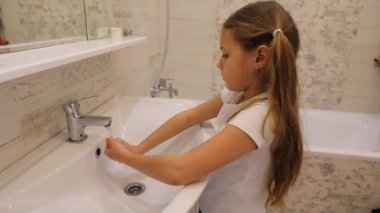 Çocuk musluğun altında ellerini sabunsuz yıkıyor. Hijyen konsepti. Ses olmadan HD video.