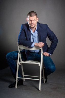 Gri arka planda ceketli bir adamın iş portresi.