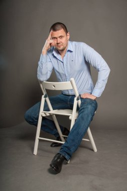 Gri arka planda ceketli bir adamın iş portresi.