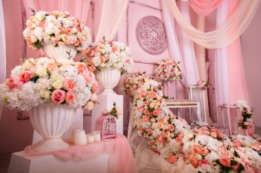 Kanepe ve çiçek bolluğu pembe ve bembeyaz. Güllerden ve öncülerden düşer