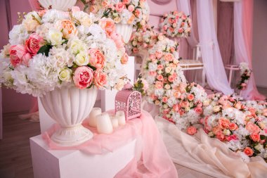 Kanepe ve çiçek bolluğu pembe ve bembeyaz. Güllerden ve öncülerden düşer