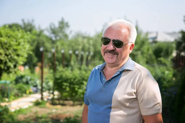 Yazın güneş gözlüklü, kır saçlı adam.