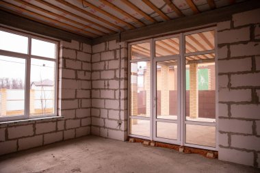 İnşaatçının onarımı olmadan daireleri tamamlamış. Son adım, köpük bloklu beyaz duvarlardan yapılmış inşaat evi. Stok Fotoğrafı Bitirilmiş Gayrimenkul