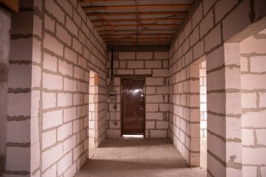 İnşaatçının onarımı olmadan daireleri tamamlamış. Son adım, köpük bloklu beyaz duvarlardan yapılmış inşaat evi. Stok Fotoğrafı Bitirilmiş Gayrimenkul