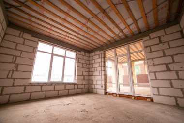 İnşaatçının onarımı olmadan daireleri tamamlamış. Son adım, köpük bloklu beyaz duvarlardan yapılmış inşaat evi. Stok Fotoğrafı Bitirilmiş Gayrimenkul