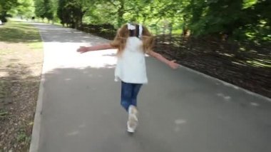 Kız parkta koşuyor. Arkadan bak. Çocuk yazın mutlu olur..