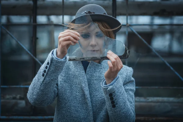 Girl looks through a piece of glass — Stock Photo, Image