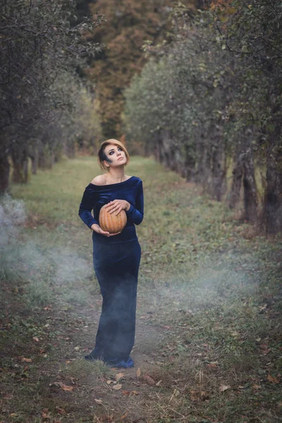 Frau im Kleid im herbstlichen Garten — Stockfoto