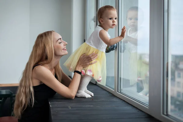 Anne ve kızı pencerenin duruyorsun