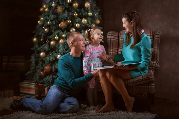 父母和女儿在圣诞树附近 — 图库照片