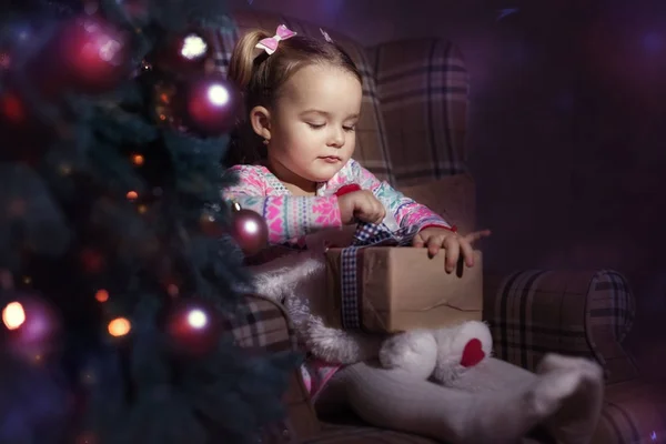 Meisje met een geschenk in de buurt van de kerstboom — Stockfoto