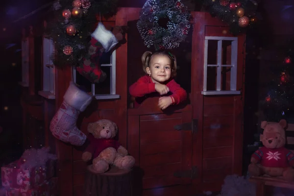 Menina em uma casa de brinquedo de Natal — Fotografia de Stock