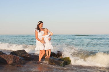 Anne ve kızı deniz kıyısında