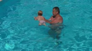 Baba ile kızı havuzda. Baba kız bebek yüzmeyi öğret