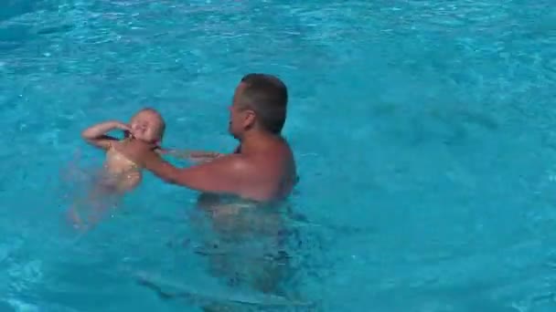 お父さんとプールで娘 お父さんが泳ぐに女の赤ちゃんを教える — ストック動画