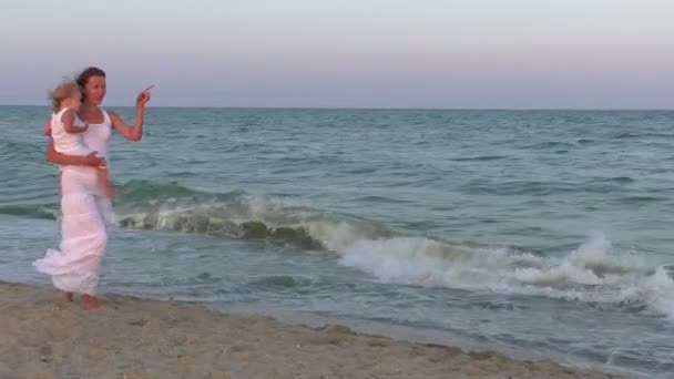 妈妈和女儿在海滩上 妈妈带着一个女儿在她的怀抱里 — 图库视频影像