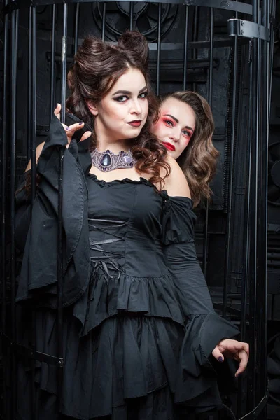 Duas belas mulheres jovens em vestidos pretos . — Fotografia de Stock