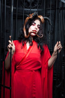 Kadın bir yılan kuyruğu tutar.