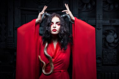 Kadın bir yılan tutuyor.