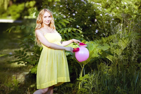 Jonge zwangere vrouw permanent in het park. — Stockfoto