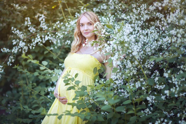 Retrato de uma bela mulher grávida em um vestido amarelo . — Fotografia de Stock