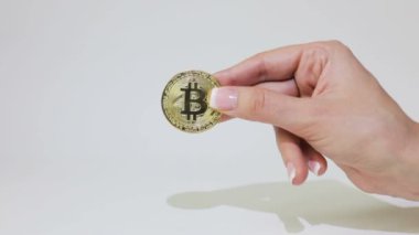 El bitcoin bir sikke parmaklarda tutar ve döner.