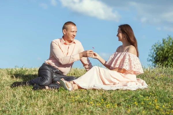 Homem e mulher sentados na grama . — Fotografia de Stock